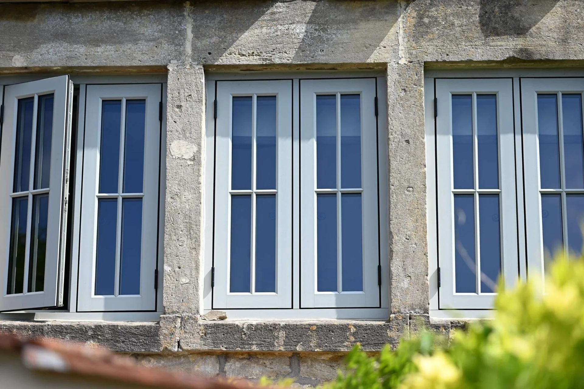 Traditional stone building with white casement windows