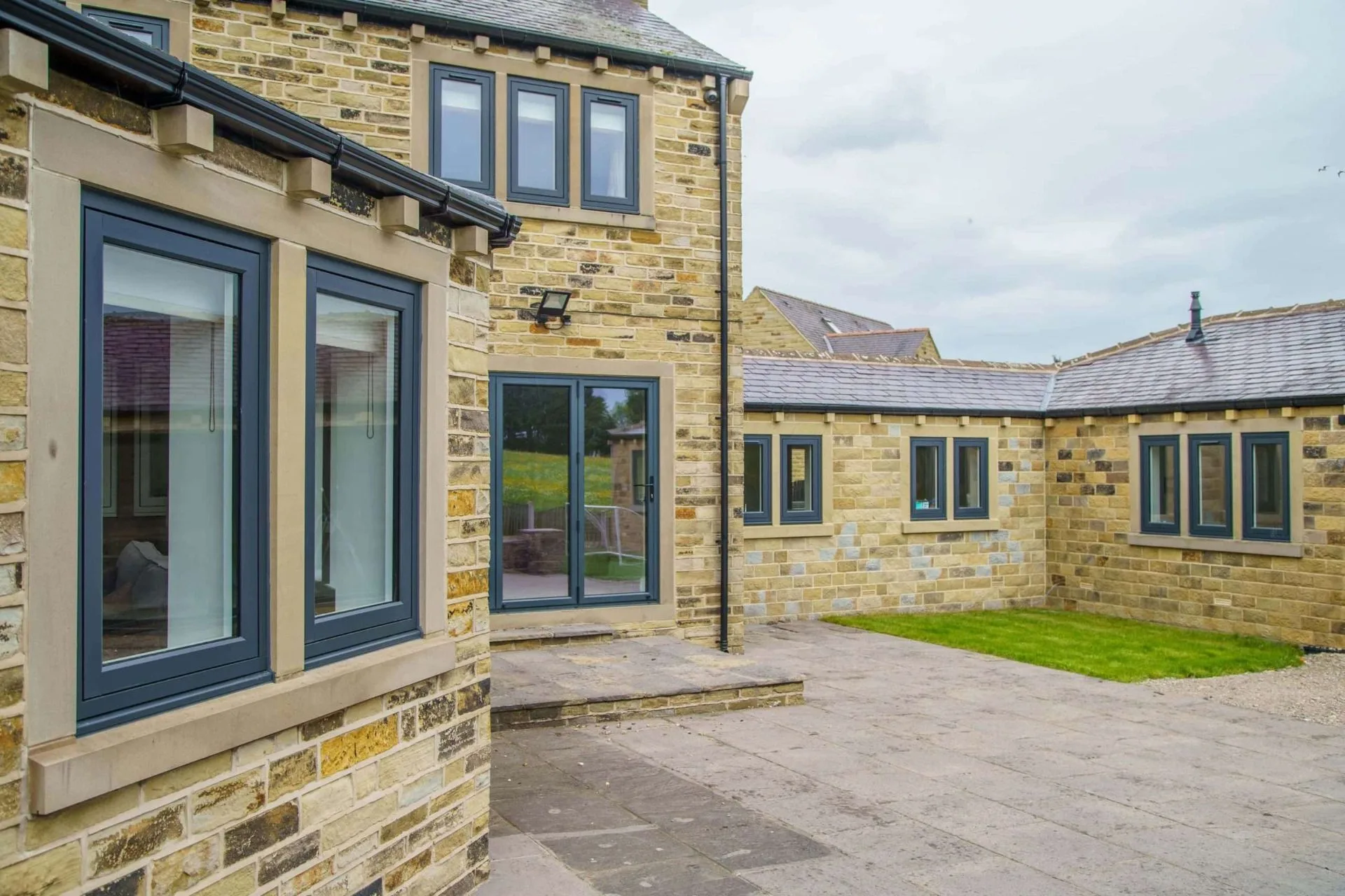 Stone building showcasing multiple grey casement windows