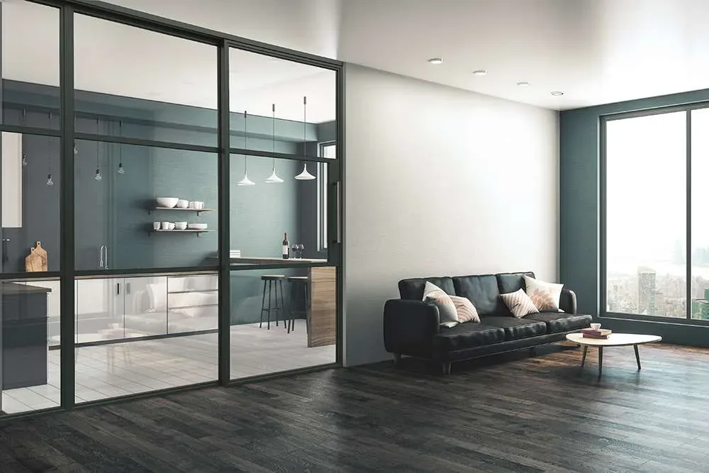 Modern apartment with glass room divider separating kitchen and living area